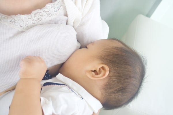 A close up of a baby breastfeeding