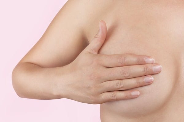 Woman covering her breast with hand